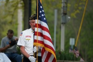 Military Veteran with American Flag | Veteran Car Donations