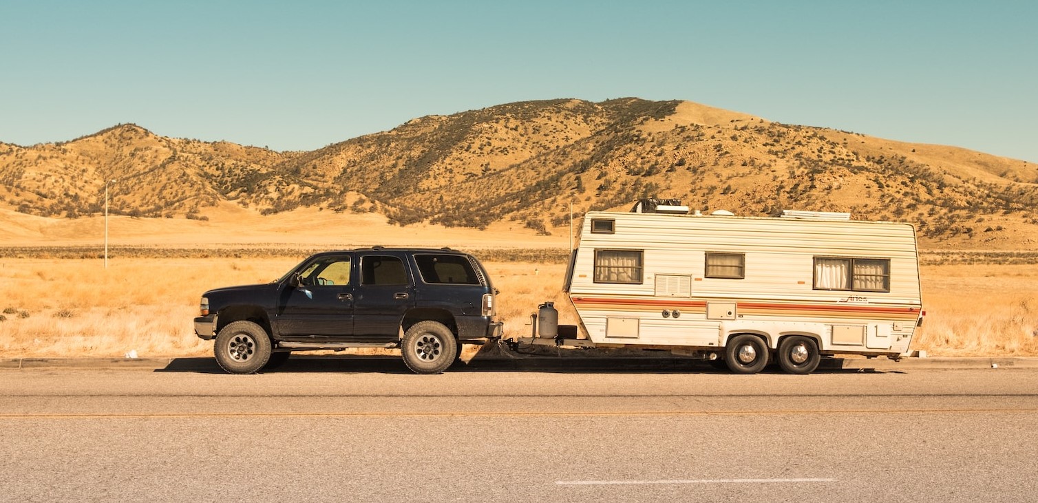 black SUV and white trailer | Veteran Car Donations