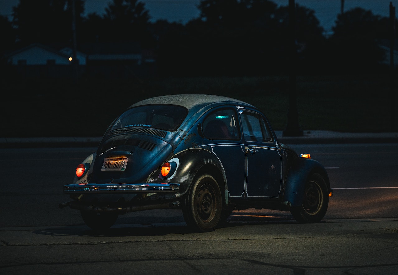 A Black Volkswagen Beetle Parked on the Road at Night | Veteran Car Donations