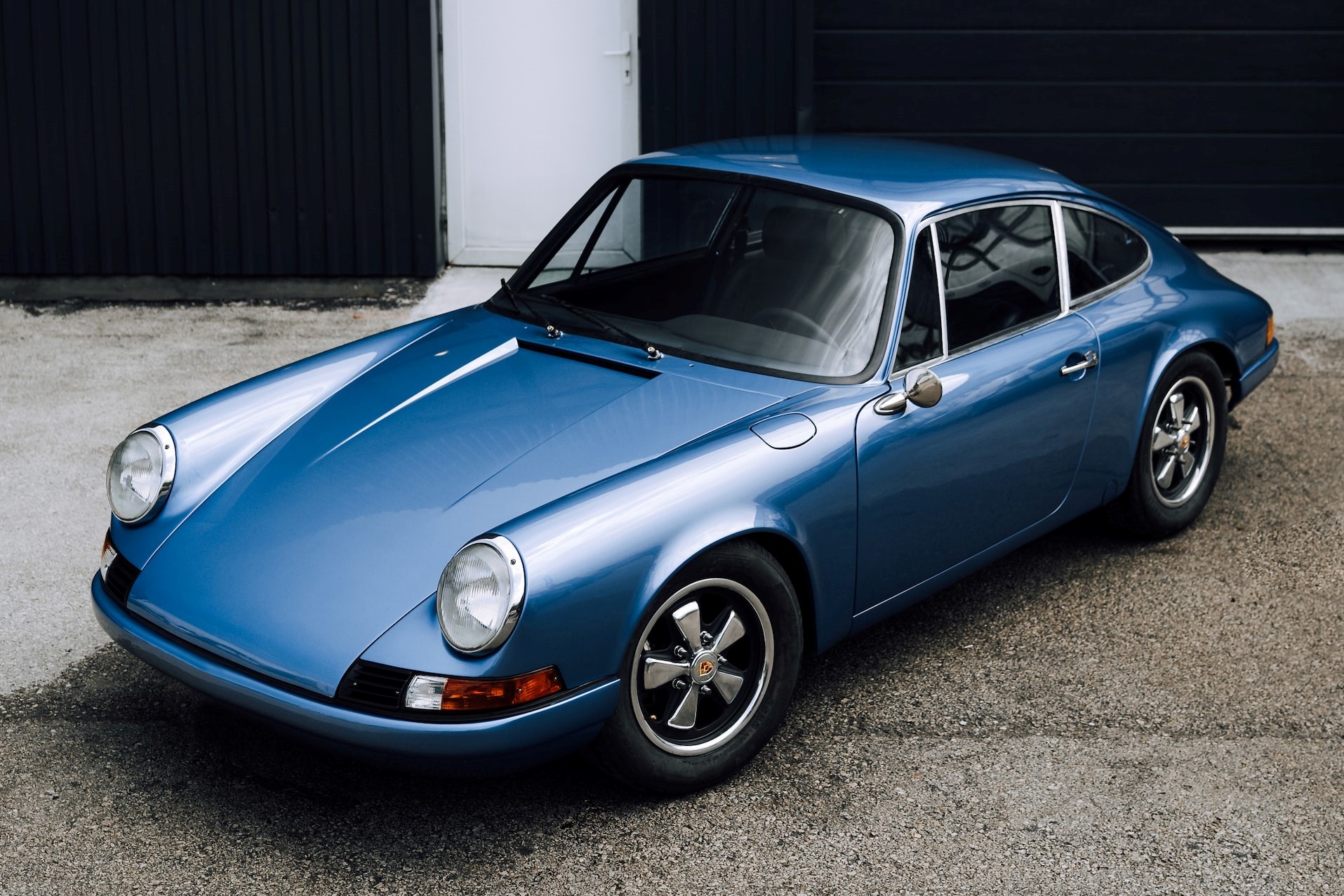Blue Porsche 911 Parked in front of White building | Veteran Car Donations