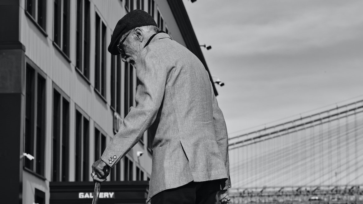 Grayscale Photo of an Elderly Man Walking | Veteran Car Donations