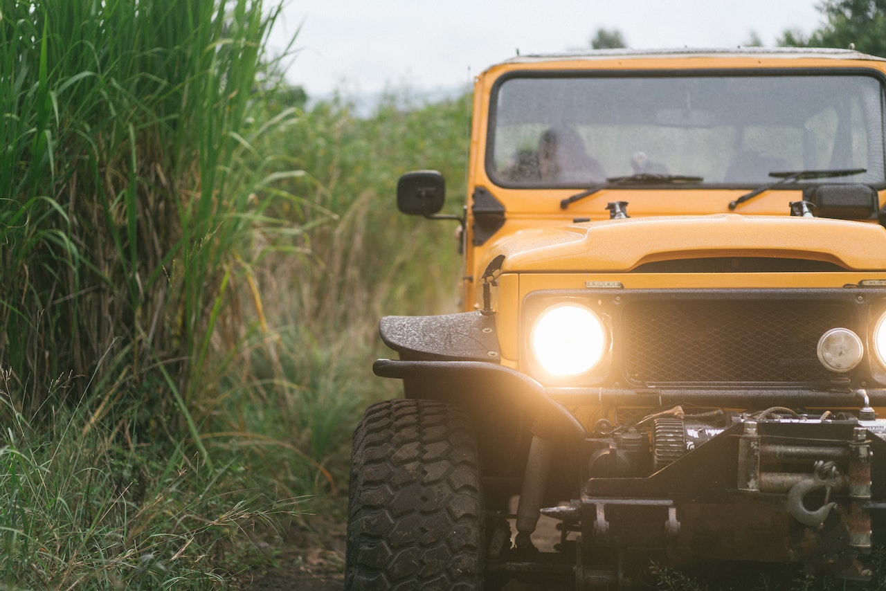 Orange car with burning headlights in countryside | Veteran Car Donations