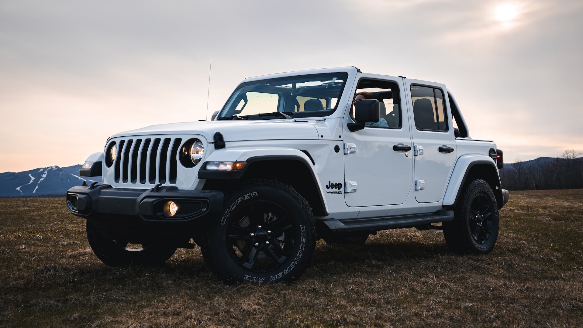 white jeep wrangler on green grass field under white clouds during | Veteran Car Donations