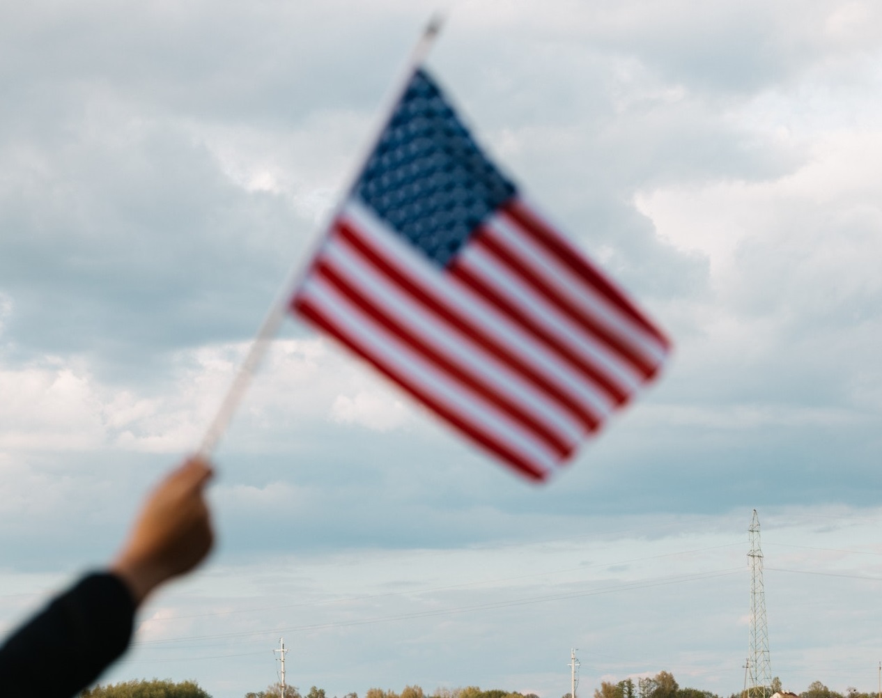 Blurry american flag on hand | Veteran Car Donations