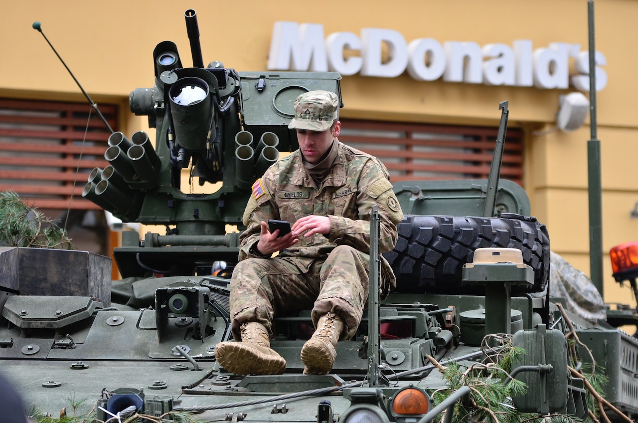 Man In Brown Camouflage Sitting on Top of Tank | Veteran Car Donations