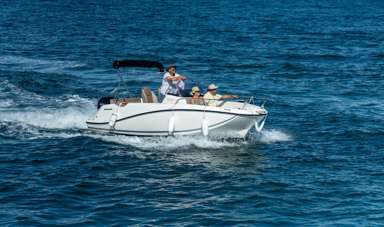 People Riding White Deckboat During Daytime | Veteran Car Donations