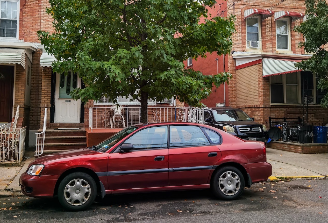 Red Sedan Parked on Road | Veteran Car Donations