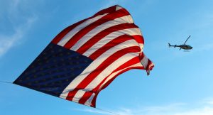 Waving US Flag and a Helicopter | Veteran Car Donations