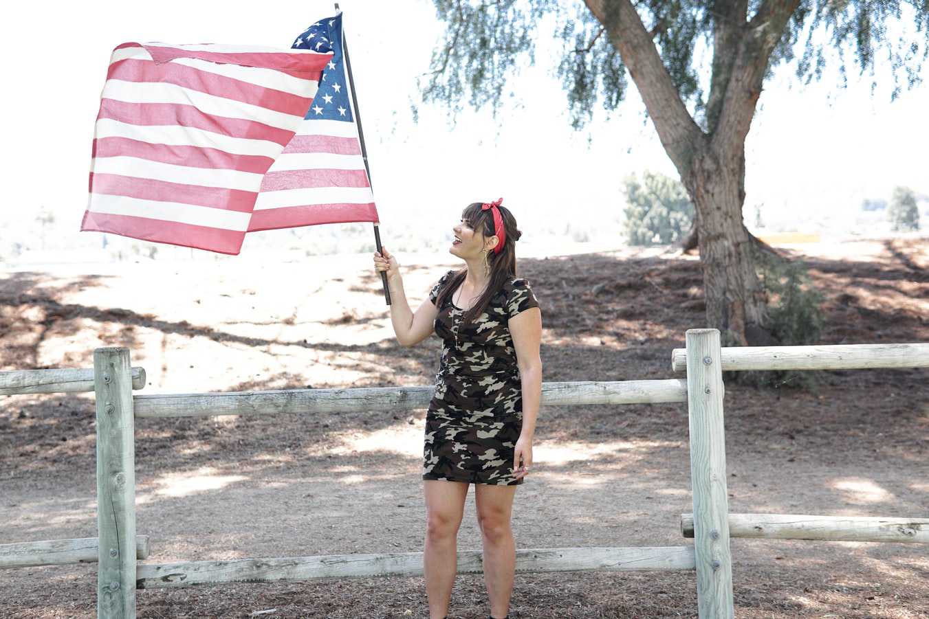 Woman Raising the US Flag | Veteran Car Donations