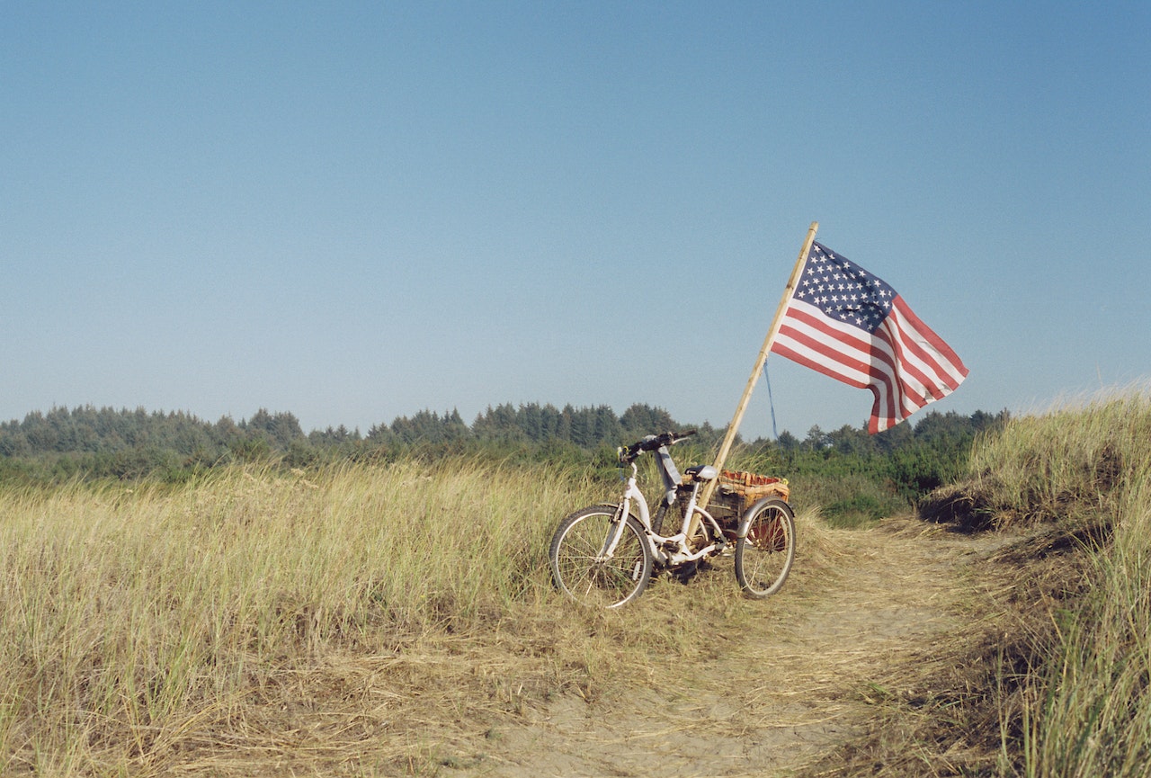 American Flag Set on a Bicycle in a Field | Veteran Car Donations
