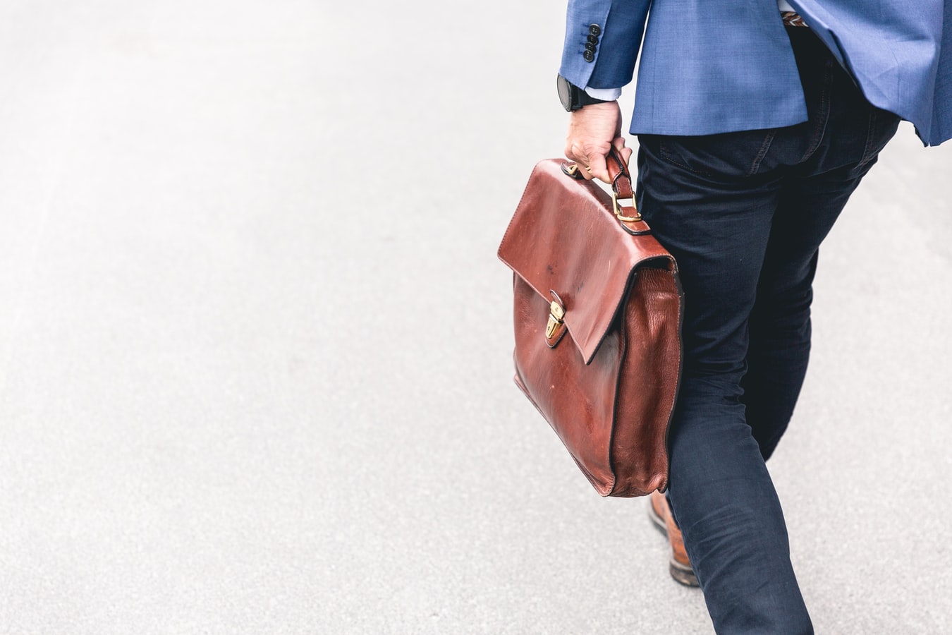 Man Holding a Brown Leather Bag | Veteran Car Donations