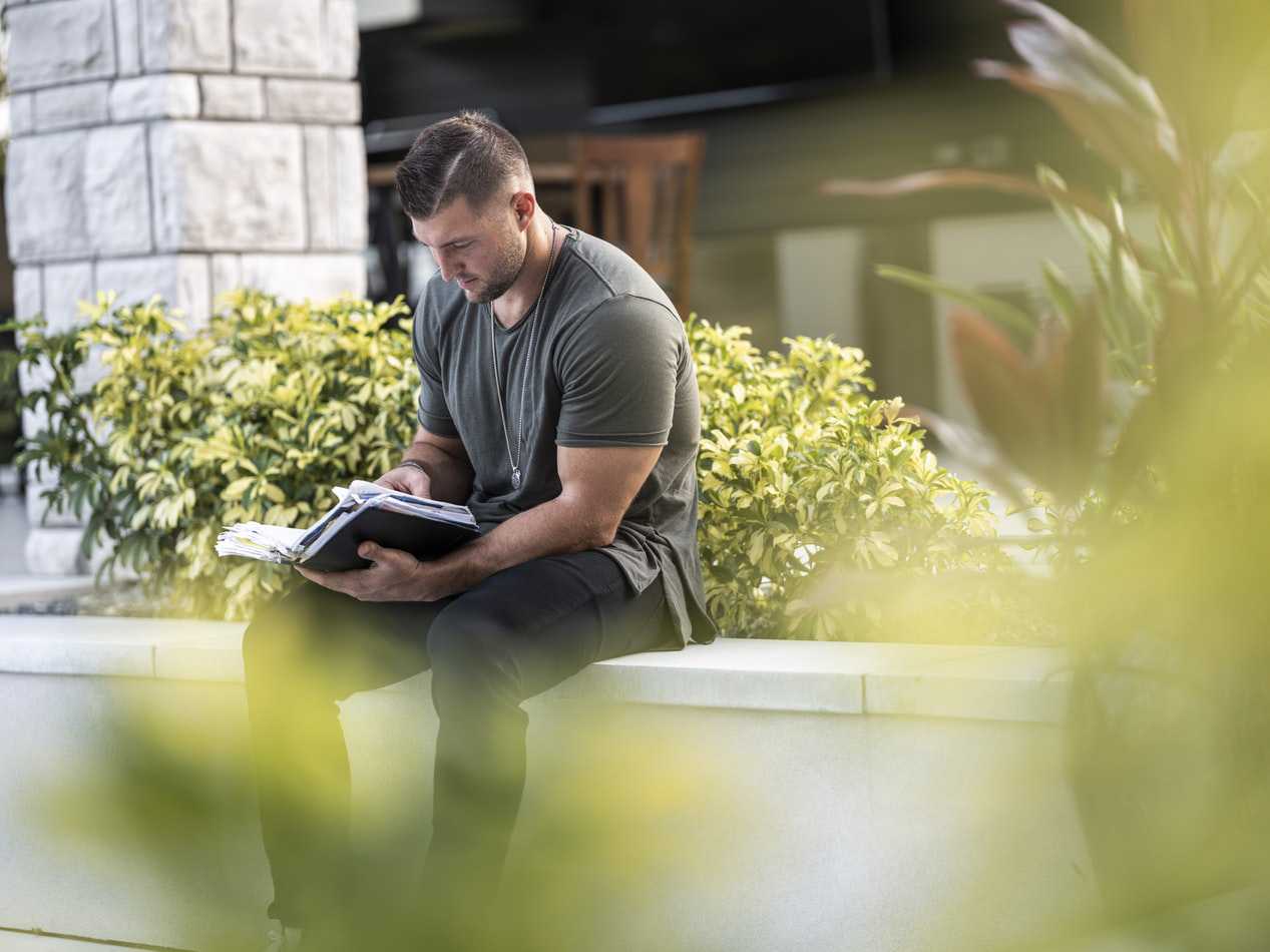 Man Reading a Book Outdoors | Veteran Car Donations