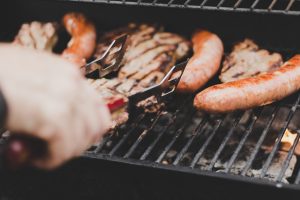 Person Grilling Sausage and Meat | Veteran Car Donations