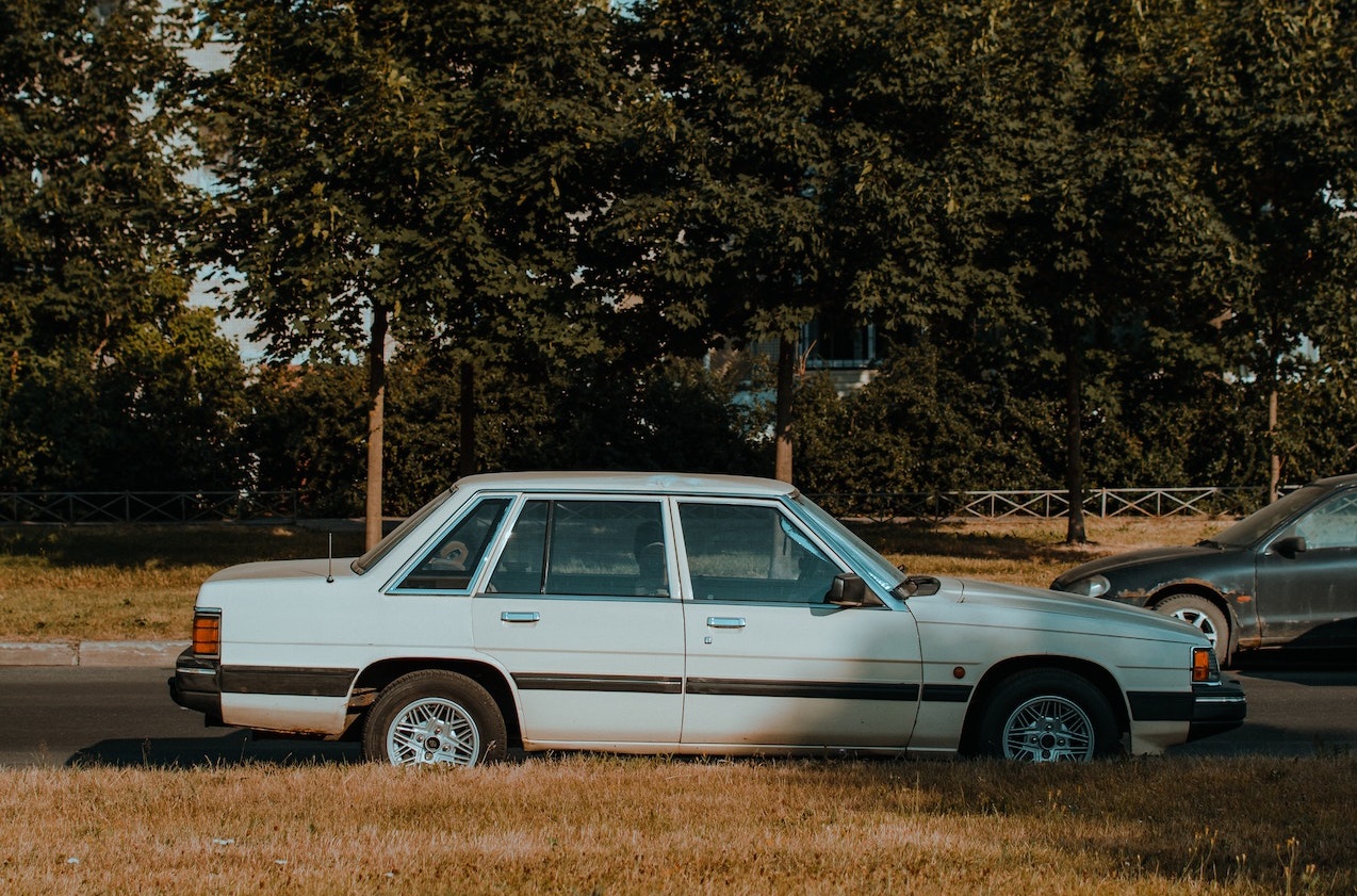 Old White Sedan Parked on Road | Veteran Car Donations