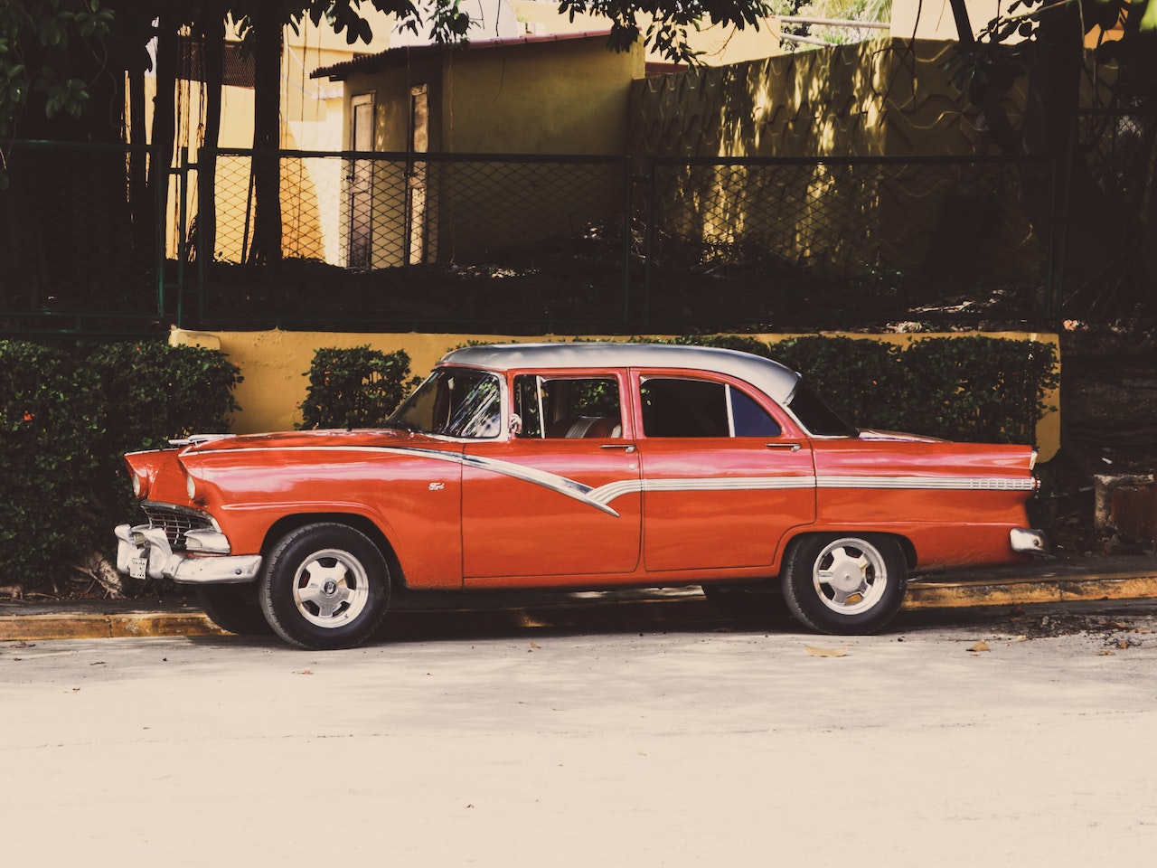 Red Sedan Parked Beside a Sidewalk | Veteran Car Donations