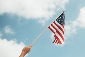Person Waving the US Flag | Veteran Car Donations