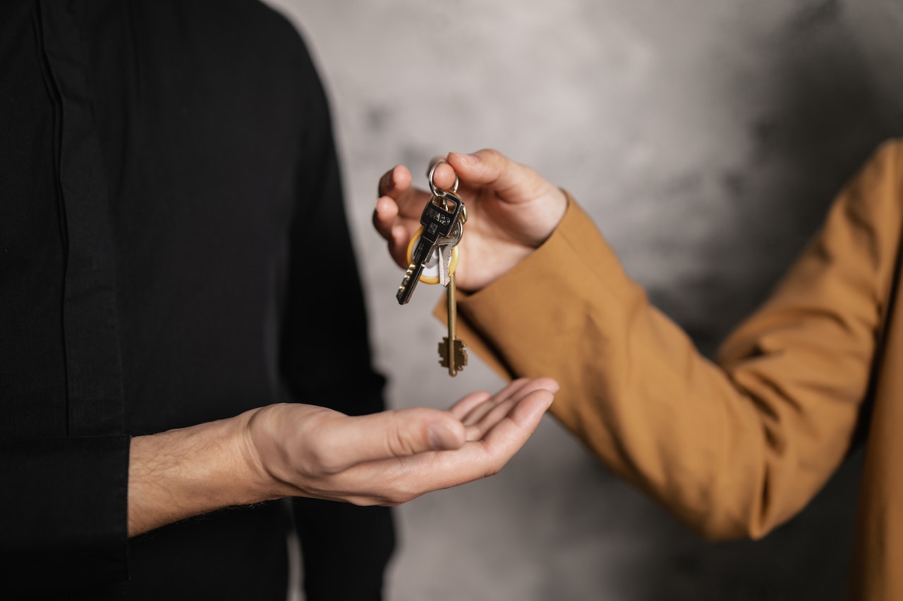 A Person Giving a Bundle of Keys to another Person | Veteran Car Donations
