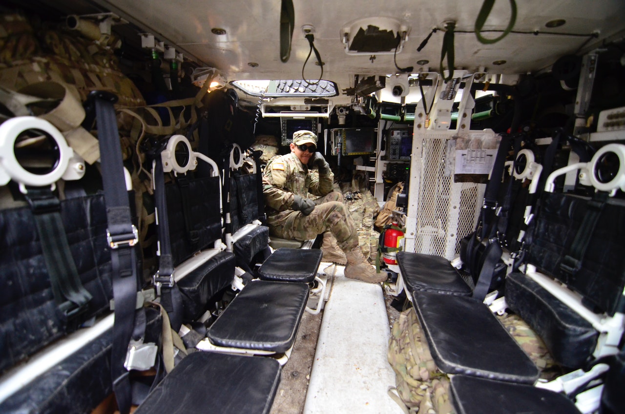 Man in Soldier Suit Sitting in Black Leather Seat | Veteran Car Donations
