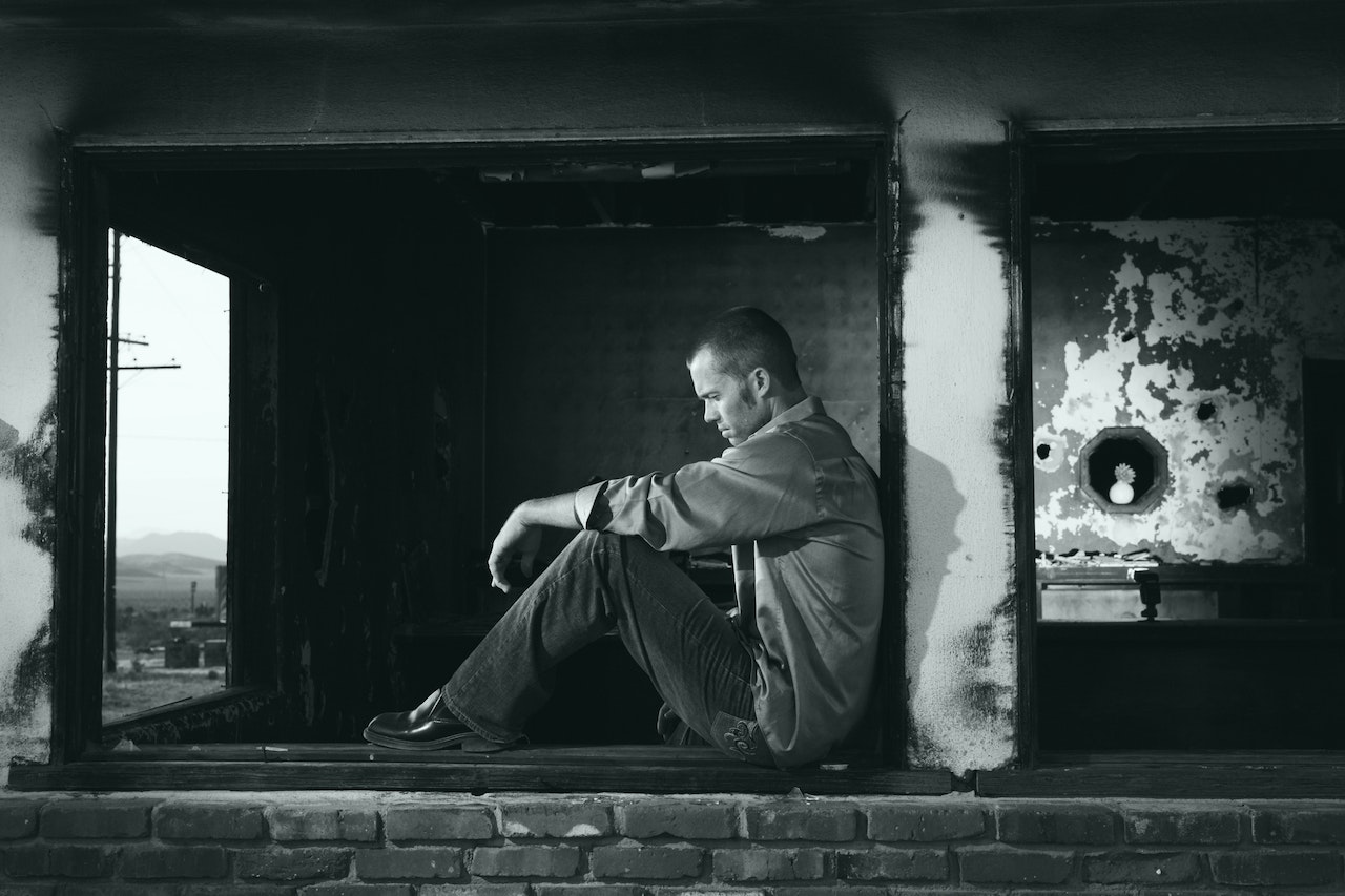 Grayscale Photo of Man Sitting | Veteran Car Donations