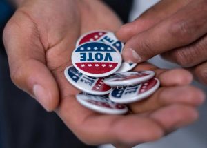 Person Holding Vote Pins | Veteran Car Donations