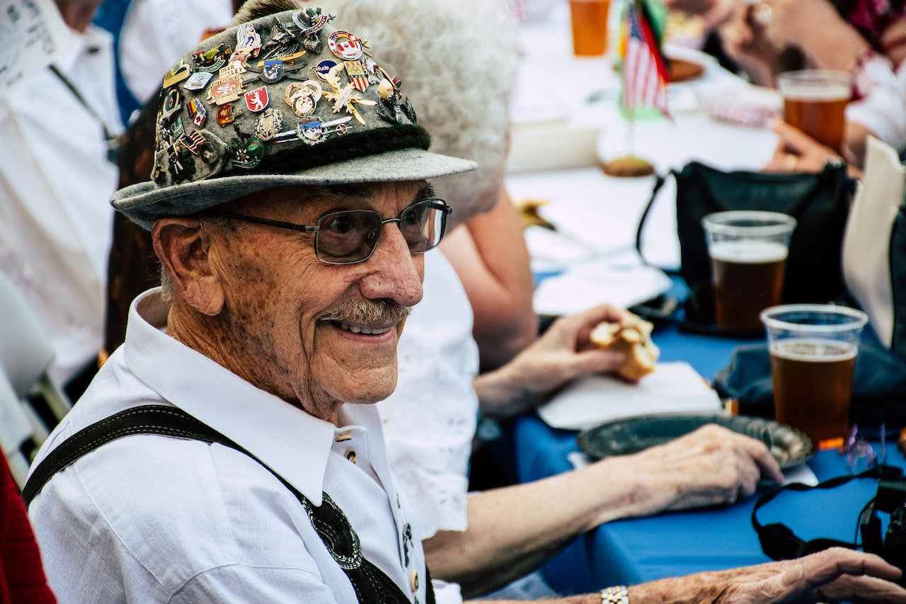 Smiling Man Sitting in Front of Blue Table | Veteran Car Donations