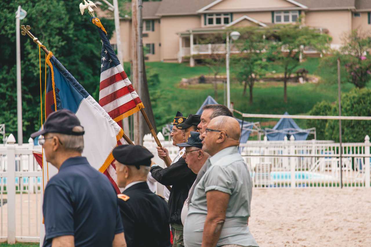 Veterans Standing Near Flags | Veteran Car Donations
