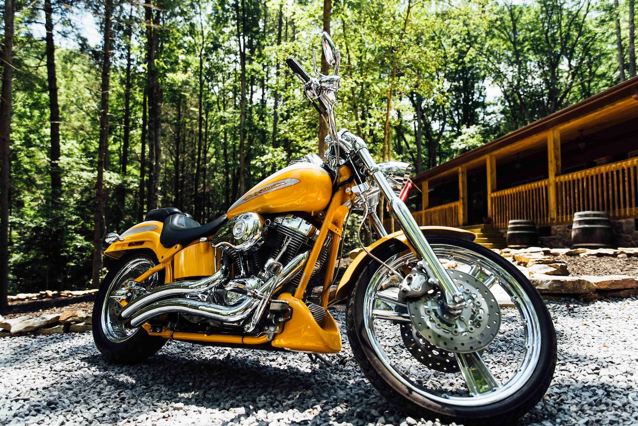 A Yellow Motorcycle Parked on Gravel Stones | Veteran Car Donations