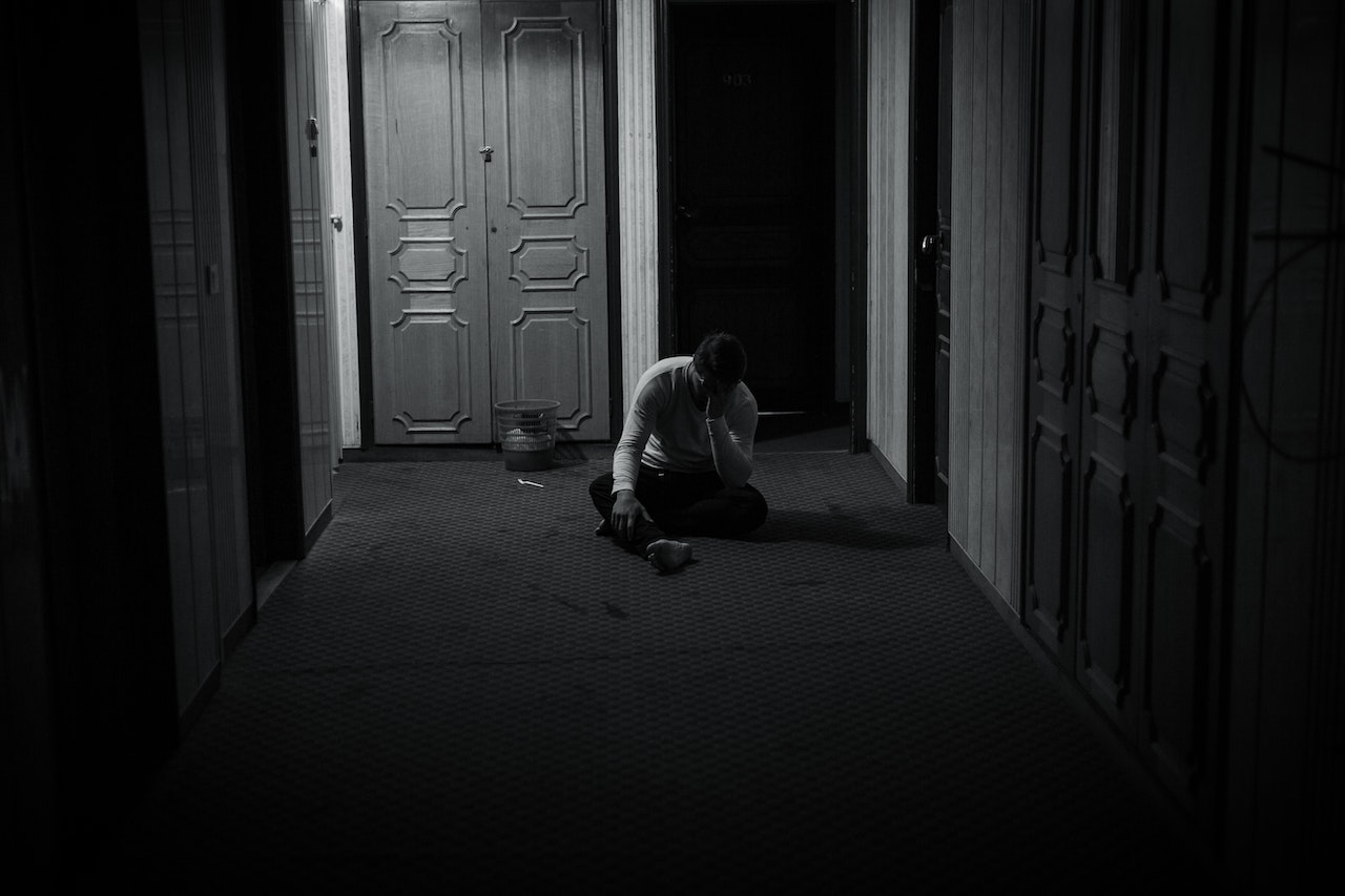 A Grayscale of a Lonely Man Sitting on the Floor | Veteran Car Donations