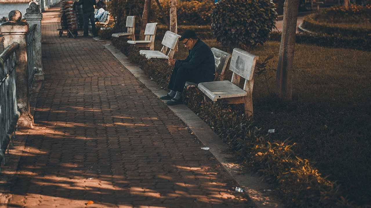 Man Sitting on a Bench Alone | Veteran Car Donations