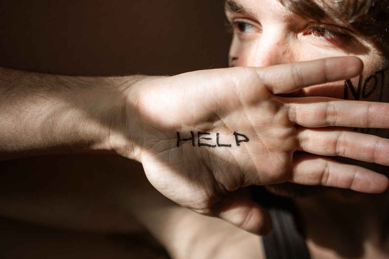 The Word Help Written on a Person's Palm | Veteran Car Donations