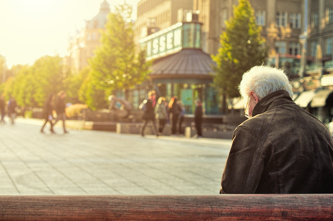 Man Sitting on Wooden Bench Wearing | Veteran Car Donations
