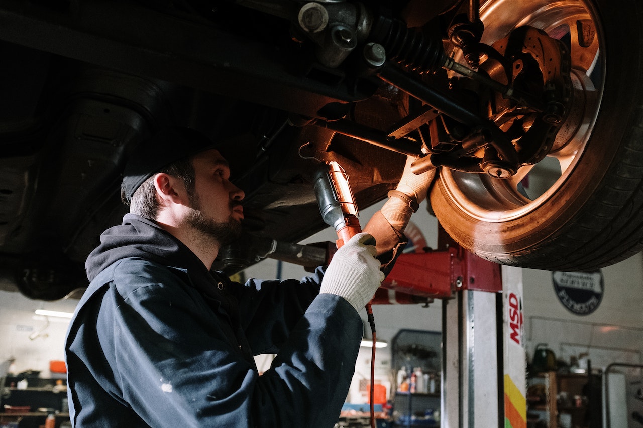 Man in Blue Dress Shirt Holding Red and Black Power Tool | Veteran Car Donations