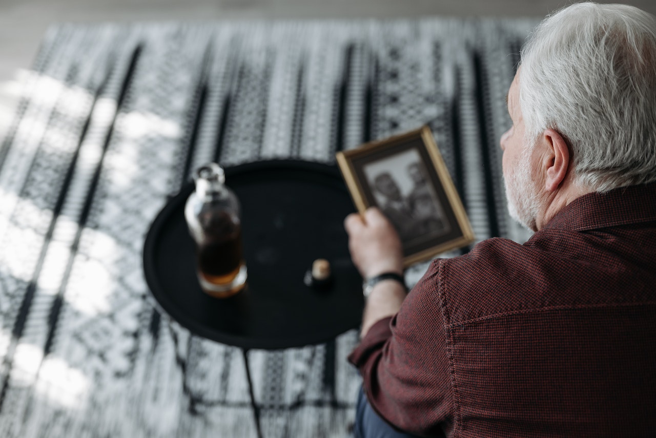 Elderly Man with Gray Hair Holding a Picture Frame | Veteran Car Donations