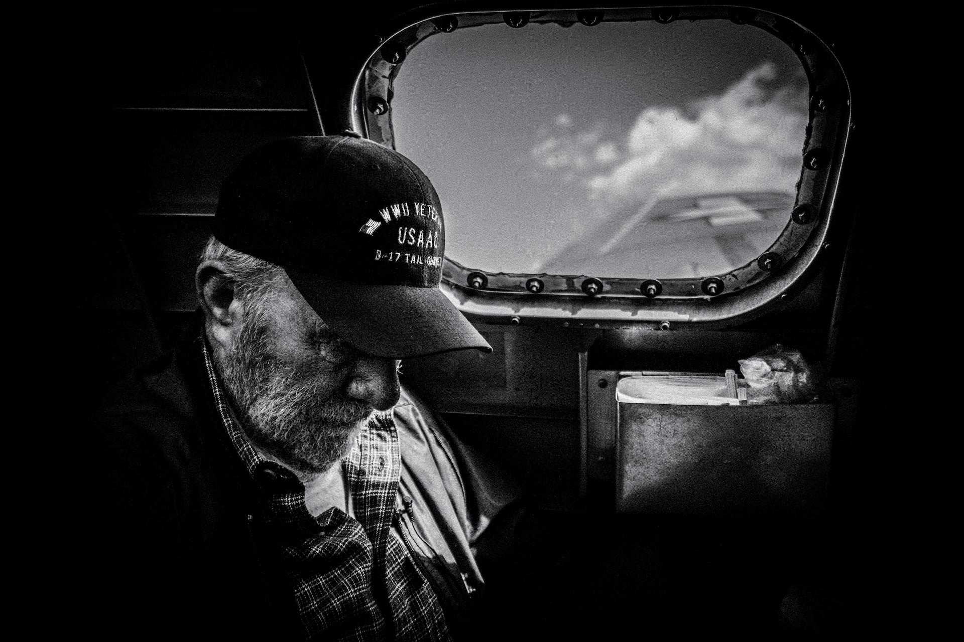 Grayscale Photo of Man in Plaid Shirt and Cap at the Sky | Veteran Car Donations
