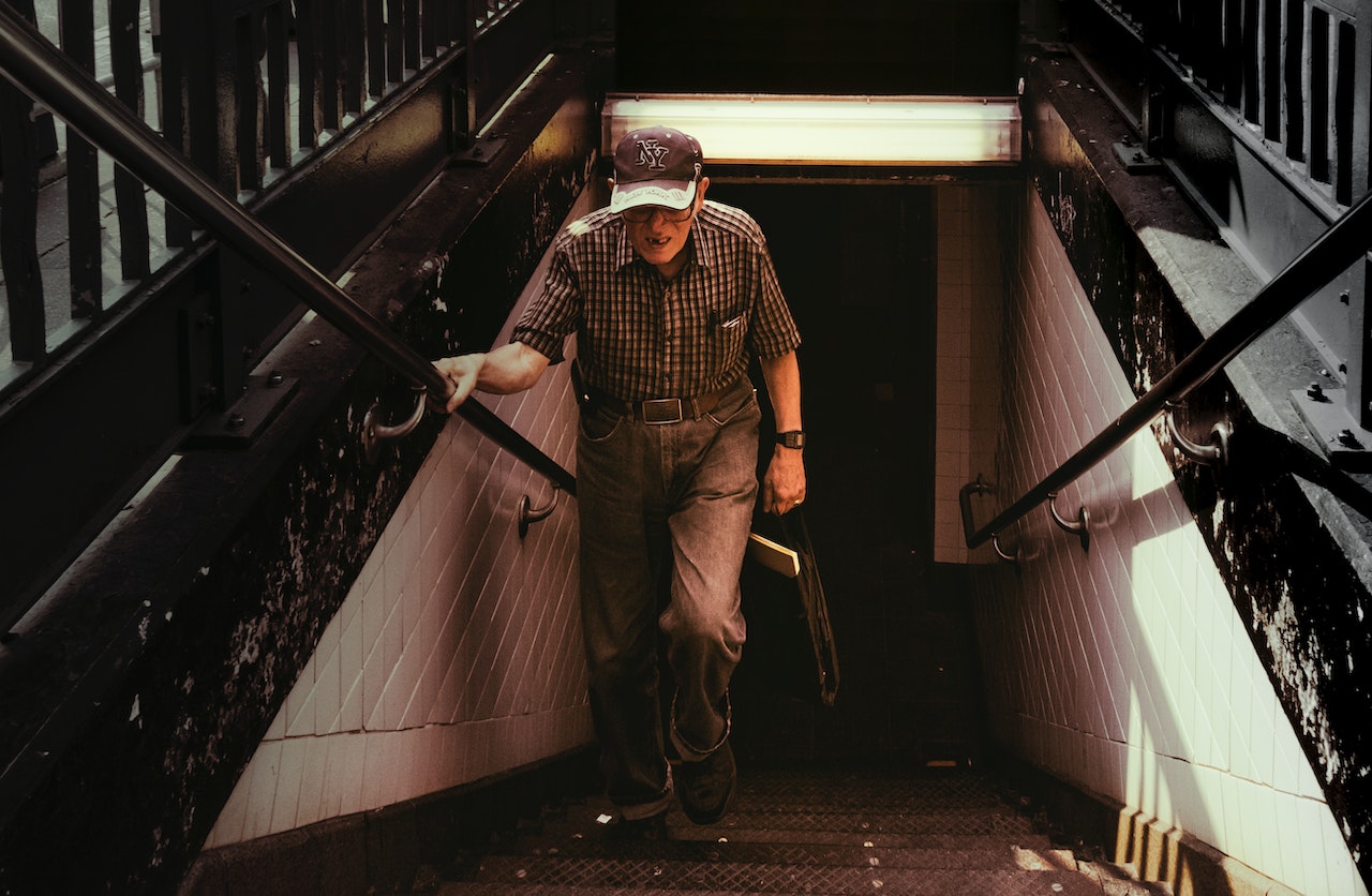 Man in Collared Shirt and Gray Pants Walking on Stairs | Veteran Car Donations
