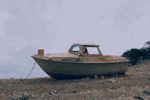 Rusted Boat Sitting on a Beach | Veteran Car Donations