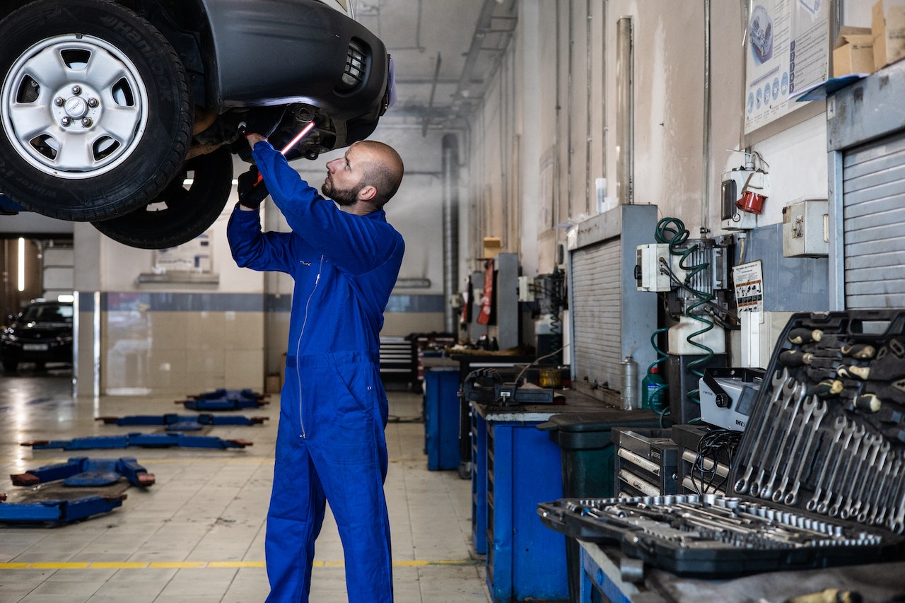 A Man in Blue Suit Checking a Car | Veteran Car Donations