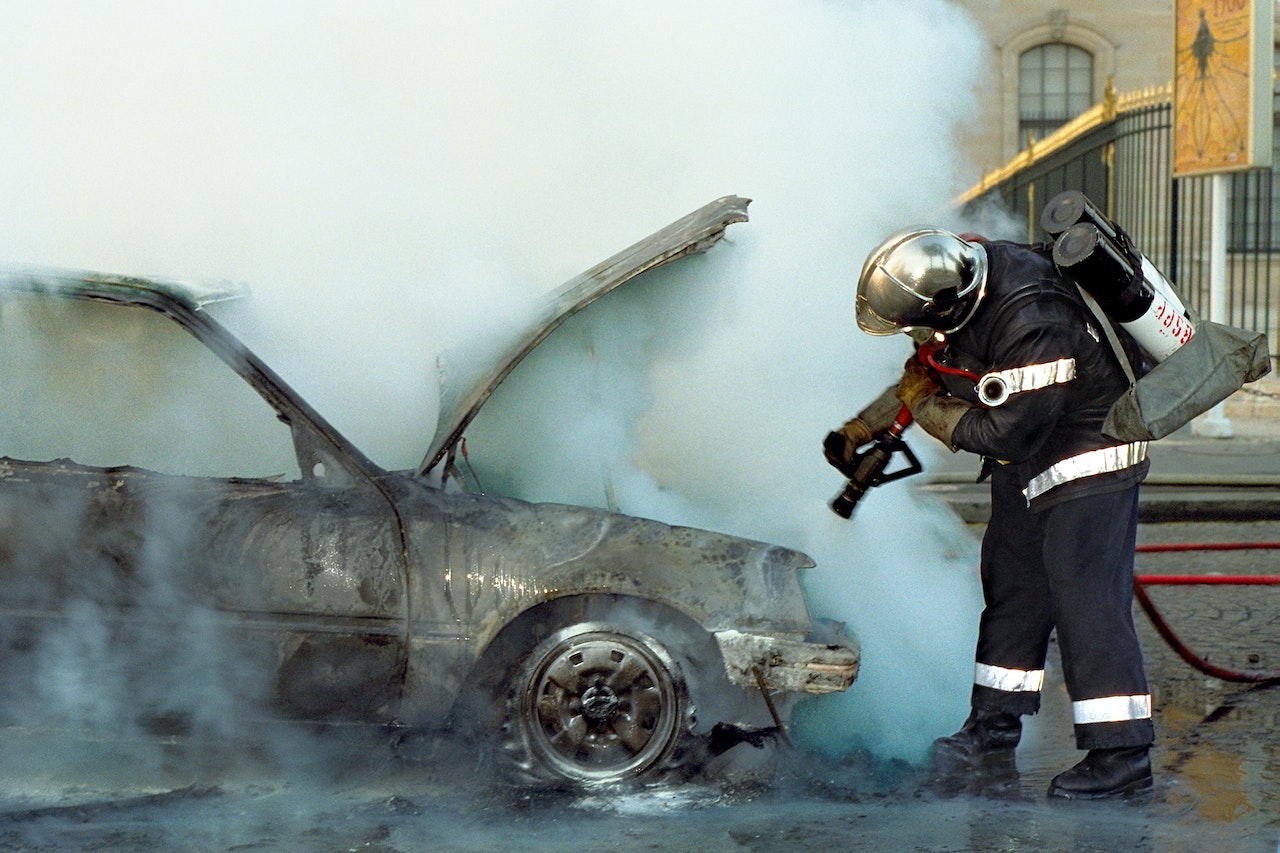 A Firefighter Extinguishing a Broken Car | Veteran Car Donations