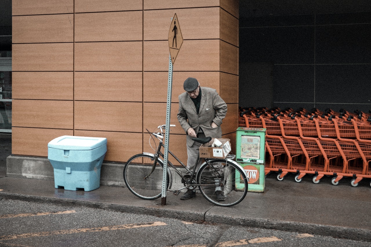 Man Parking a Bicycle Near Brown Wall | Veteran Car Donations
