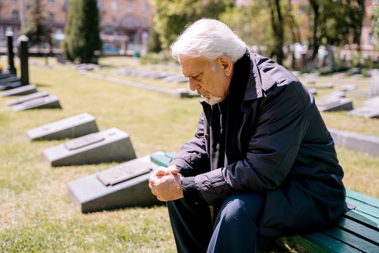 A Sad Elderly Man Sitting on a Bench | Veteran Car Donations

