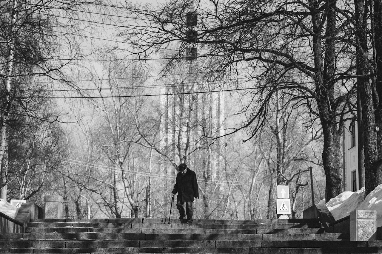 Elderly Man Walking on Concrete Stairs | Veteran Car Donations
