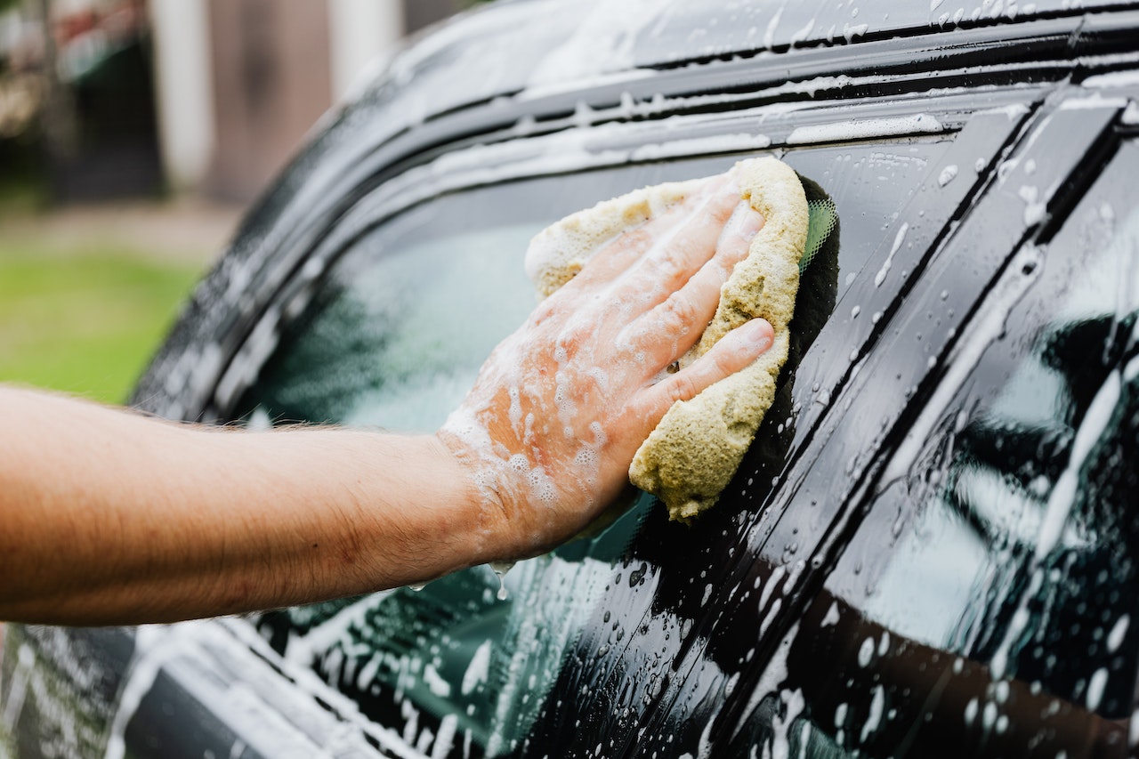 Person Holding a Sponge Washing His Car | Veteran Car Donations
