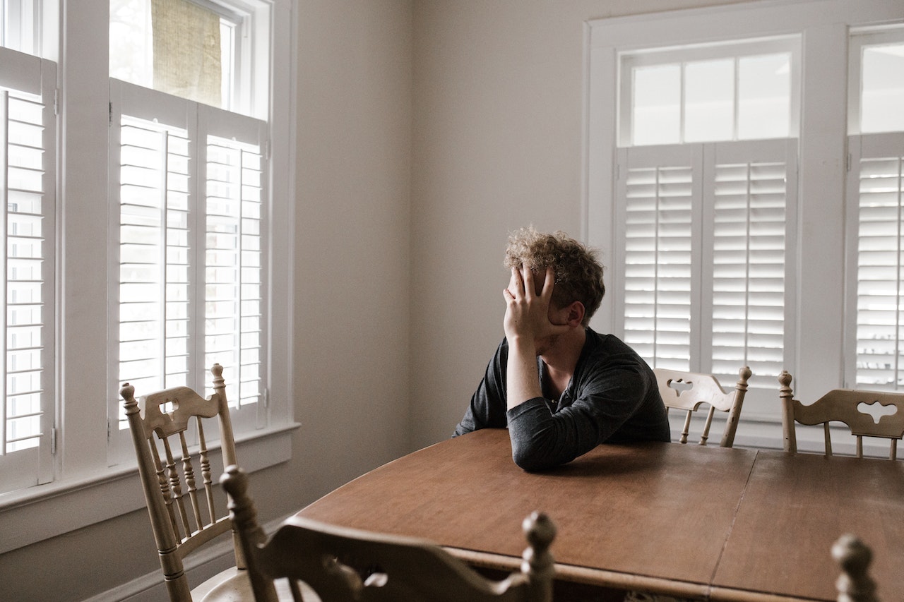 Photo of Man Leaning on Wooden Table | Veteran Car Donations
