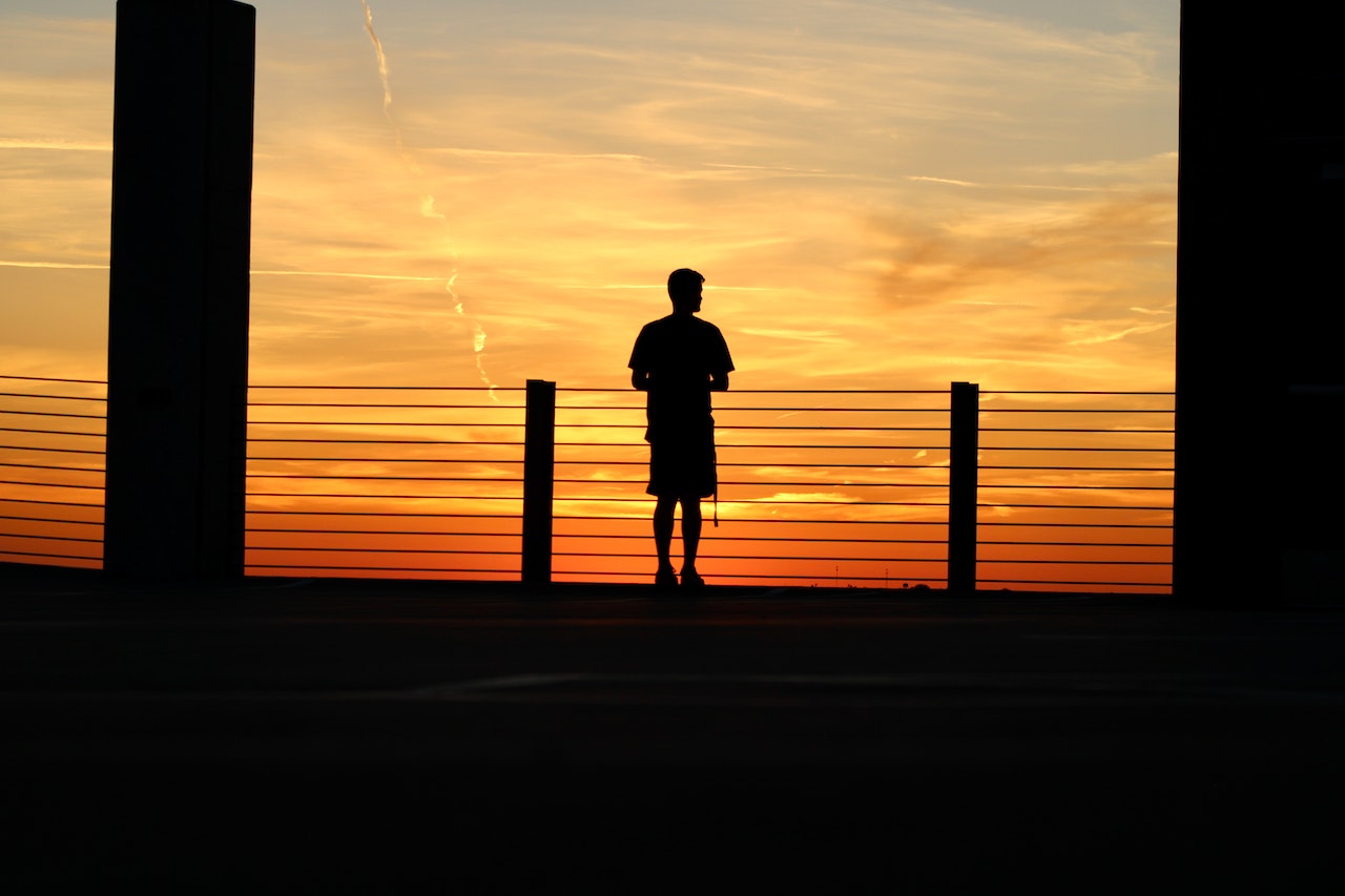 Silhouette of a Man Standing near a Railing | Veteran Car Donations
