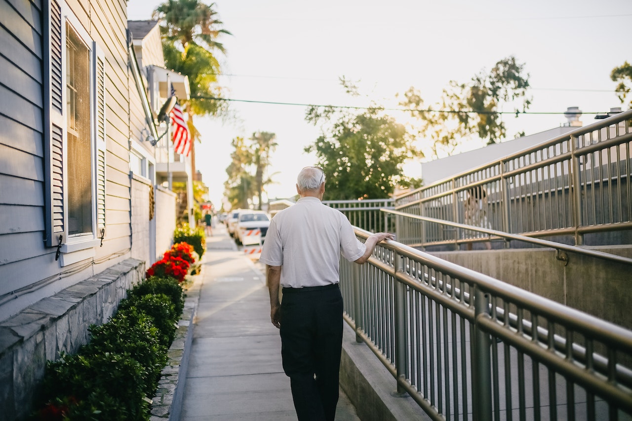 Man in White Shirt and Black Pants Standing on Gray Concrete Pathway | Veteran Car Donations
