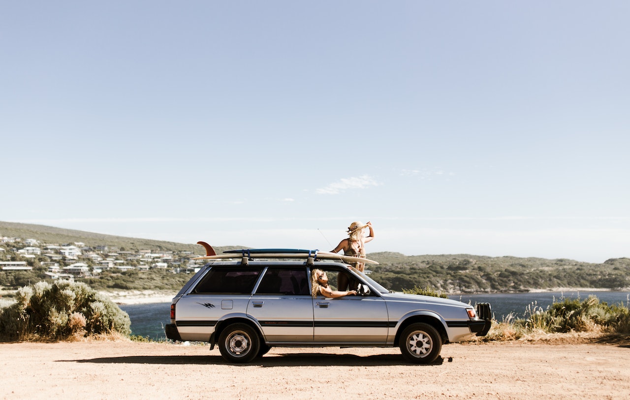 Unrecognizable tourists looking out of car on rough road | Veteran Car Donations