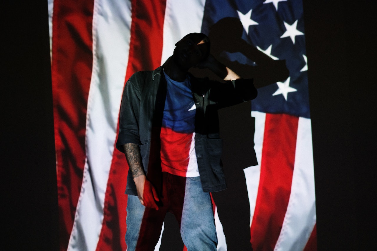 Man Standing in Front of a Projection of the American Flag | Veteran Car Donations
