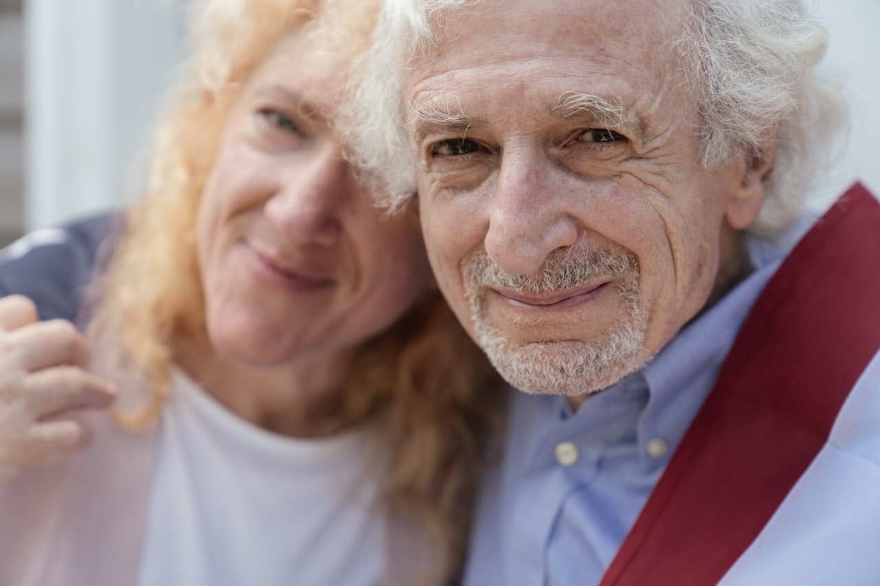 Close-up of an Elderly Couple Draped with the American Flag | Veteran Car Donations