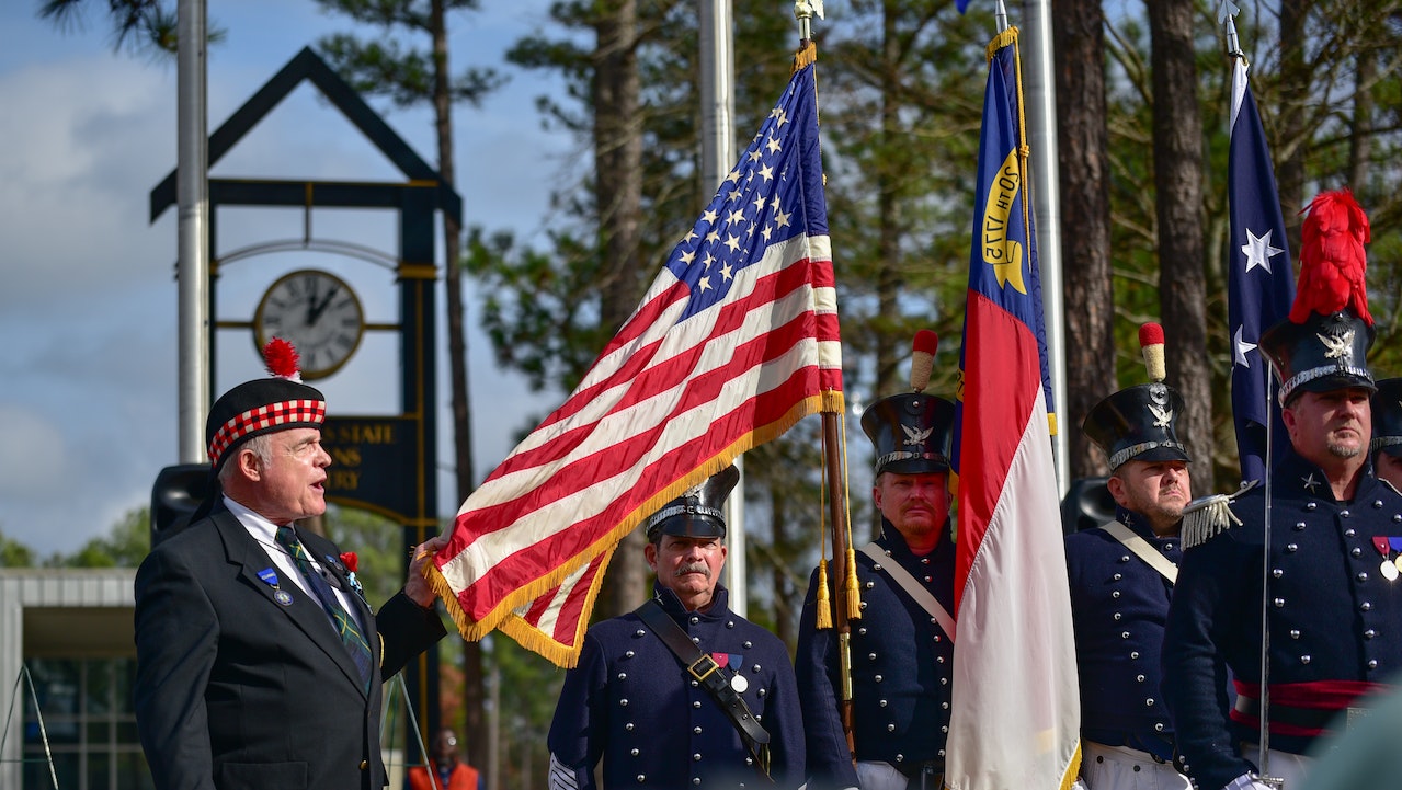 People Holding US Flags | Veteran Car Donations
