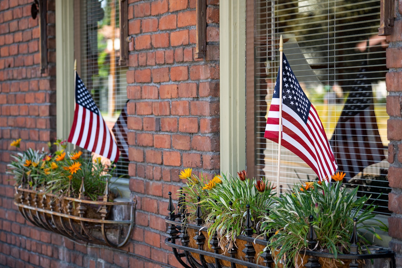 US Flags on Flower and Green Plants | Veteran Car Donations
